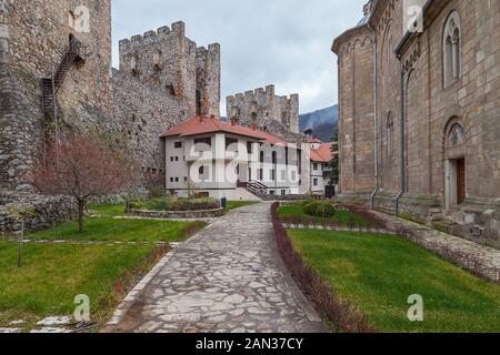 Schöner Hinterhof und Park in den Mauern der Festung am Manasija-Kloster: Grünes Gras, wehrhafte Türme und felsige Pflaster Stockfoto