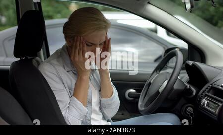 Blonde Frauen leiden unter starken Migräne, Sitzen im Auto, Kopfschmerzen Störung Stockfoto