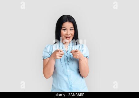 Freestyle. Asiatische Frau, die isoliert auf weißem zeigen auf Kamera verspielt Stockfoto