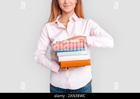 Freestyle. Junge Studentin auf Weiß mit Bücher schließen isoliert, lächelte zuversichtlich Stockfoto