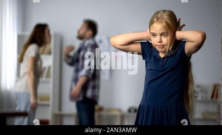 Scheidung und Kinder, unglückliche Mädchen leiden Streitigkeiten zwischen Eltern Stockfoto