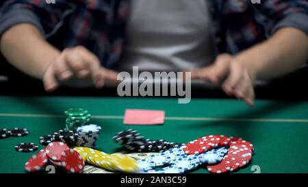Casino Client wirft seine Chips und Geld auf den Tisch, alle Wetten im Poker Spiel Stockfoto