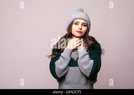 Süßes, ungesundes Weibchen im Hut, in warmen Schal gewickelt, niest, erlebt Allergiesymptome, erwischt eine Erkältung. Kranke verzweifelte Frau hat Grippe. Stockfoto