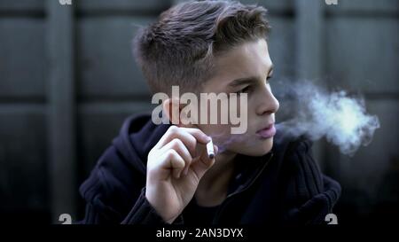 Teenager boy rauchen Zigarette, schädlichen Neigung und so tun, als cool zu sein Stockfoto