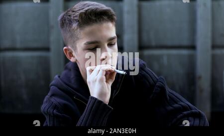 Teenager boy rauchen Zigarette in Gateway, versteckt von den Eltern, von den schlechten Einfluss Stockfoto