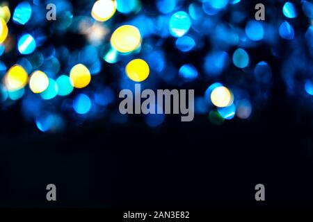 Trendige blaue und gelbe Kreise bokeh festliche Glitter dunklen Hintergrund mit kopieren. Weihnachtsbeleuchtung bokeh overlay Muster. Moderne Farbe abstrakte de Stockfoto