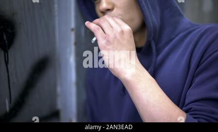 African American guy Einatmen von Zigarettenrauch, Verstecken von Erwachsenen, Depression Stockfoto