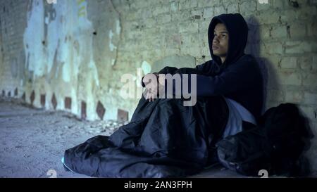 Obdachlose Flüchtlinge sitzen in Gateway, Vorbereitung zur Übernachtung im Schlafsack Stockfoto