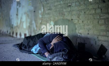 Armut, Obdachlose jungen Mann auf der Straße schlafen, gleichgültig egoistischen Gesellschaft Stockfoto