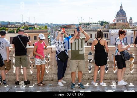 Touristen in kurzen Hosen und Sommer Kleidung bewundern Sie die Aussicht und selfies nehmen an der Spanischen Treppe in Rom Stockfoto