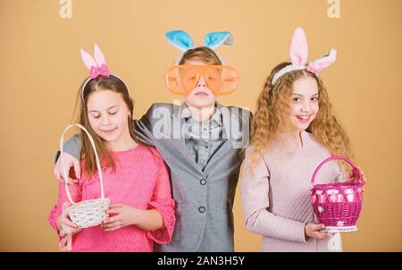 Kinder mit Körbchen bereit Jagd für Ostereier. Bereit für Eier Jagd. Gruppe Kinder Hasenohren Zubehör feiern Ostern. Ostern Aktivität und Spaß. Freunde Zusammen Spass haben am Ostersonntag. Stockfoto