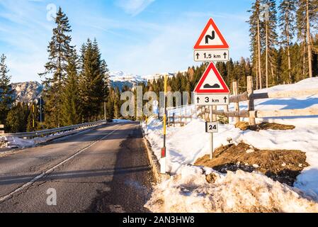 Triangualr Warnung entlang einem Pass gelöscht vom Schnee in den Alpen auf einem sonnigen Nachmittag Stockfoto