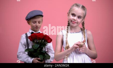 Romantische junge bereit, Blumenstrauß aus roten Rosen, kleine Dame Valentines Tag zu präsentieren Stockfoto