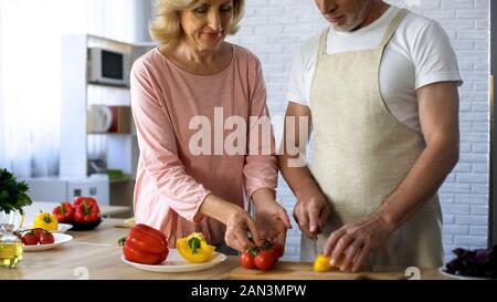 Ältere Menschen und liebevolle Frau Kochen gesunde Gemüse Mittagessen in Küche, Familie Stockfoto