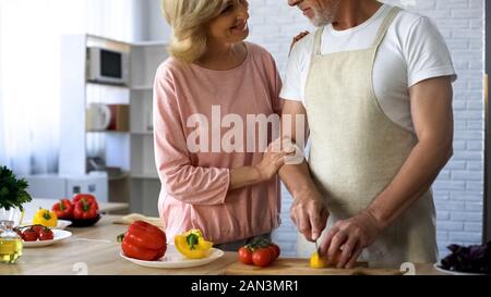 Pflege Ehemann im Vorfeld schneiden Frischer Pfeffer für den Salat, Frau, Beziehungen Stockfoto