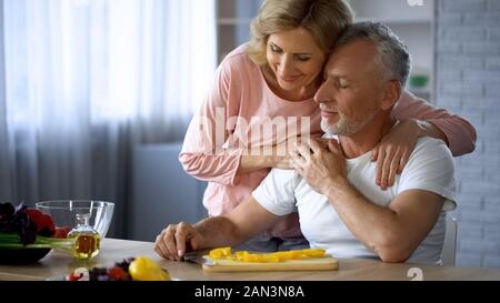 Happy Rentnerehepaar umarmen zu Hause Küche, Liebe und Harmonie, Kochen, Freizeit Stockfoto