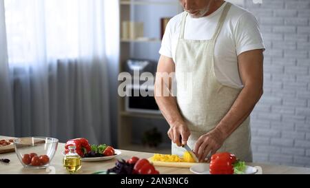 Älterer Mann im Vorfeld schneiden frischer Salat in der Küche, Kochen, Tipps, Freizeit Hobby Stockfoto