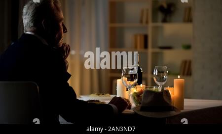 Nachdenklich stattlichen Herren warten auf Frau, serviert am Tisch sitzen, Datum Stockfoto