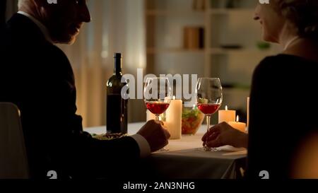 Reife elegante Männlichen und Weiblichen holding Weingläser, einander mit der Liebe Stockfoto