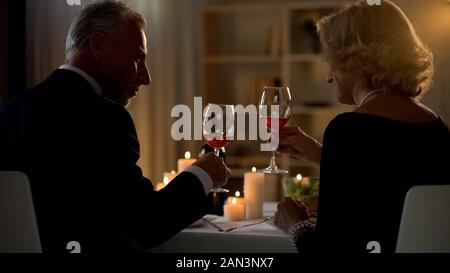 Eleganten Mann und Frau mit Rotwein Gläser, Senior Paar auf Datum, Liebe Stockfoto
