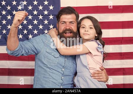 Ehrenkompanie der grosse Banner. Patriotische Familie feiern Flag Tag mit Banner Dekor. Vater und Tochter auf die amerikanische Fahne Hintergrund. Mann und einem kleinen Kind mit nationalen us banner Bärtigen. Stockfoto