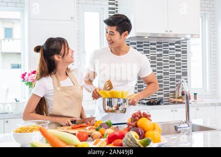 Happy Asiatisches junges Ehepaar für die Herstellung von Spaghetti Bolognese in der Küche vorbereiten. Freund und Freundin zusammen kochen. Menschen Lebensstil und Ro Stockfoto