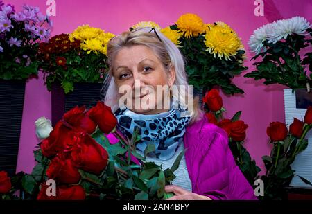 Frau Verkäufer eines Flower Shop steht mit einem Blumenstrauß in der Hand Stockfoto