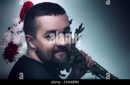 Ein Mann hält einen Strauß Blumen auf seiner Schulter Stockfoto