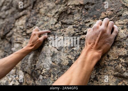 Closeup Perspektive auf ein Kletterer aufsteigend ein Kalkstein in der Natur. Weißer Kreide für Hände und Finger zu trocknen, Schweiß und erhöhen die Reibung Stockfoto