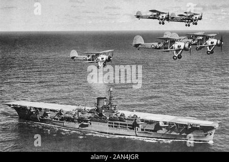 Britischer Flugzeugträger Ark Royal mit einem Flug von 'Swordfish' über dem Kopf, ca. 1939 Stockfoto