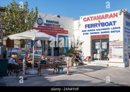 Bodrum, Türkei - 15. September 2019: Volk setzte sich außerhalb der Katamaran und Fähre Ticket Office. Fähren klicken Sie auf mehreren griechischen Inseln. Stockfoto