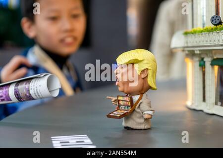 Ein Besucher schaut sich die abgedrehten Miniatur der amerikanische Präsident Donald Trump Verkauf von Zigaretten und der japanische Ministerpräsident Shinzo Abe verkaufen Pop Hühneraugen Stockfoto