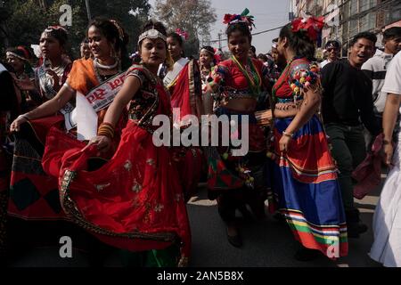 Nepalesische Frauen aus der Tharu Gemeinschaft tragen ethnischen Outfits singen und tanzen wie sie Teil während der Parade die Kennzeichnung der Magh Sankranti oder Makar Sankranti Festival. Makar Sankranti auch als Maghi bekannt, ist vor allem durch die endogene Gruppen von Nepal, Tharu, Kirant, Newar beobachtet. Je nach Kultur Experten, Tharu und Kirat beobachten Maghi in das Neue Jahr. Stockfoto