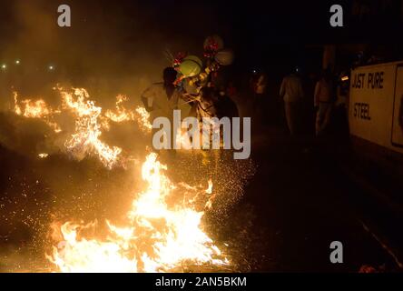 Vieh Sprung über das Feuer zusammen mit ihren Hundeführern während des Festivals. Kichchu haisodu ist ein Festival, das nach der Ernte Saison, wo Stiere über dem Feuer auf Makar Sankranti für gutes Omen gesprungen sind. Es gibt auch einige wissenschaftliche Grund laut der Einheimischen, die im Winter Insekten wächst auf dem Vieh Skins, so, es loswerden die Rinder werden über das Feuer zu springen. Stockfoto