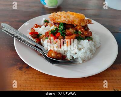 Die knusprigen Schweinebauch mit Thai-basilikum und Spiegelei auf Reis Stockfoto