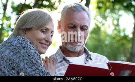 Schöne ältere Familie Paar anzeigen Photoalbum, angenehme Jugend Erinnerungen Stockfoto