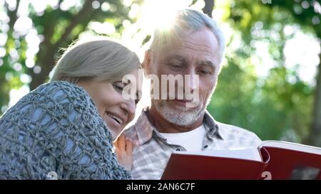 Cute senior Paar anzeigen Photoalbum, erinnern, lustige Momente des Lebens Stockfoto