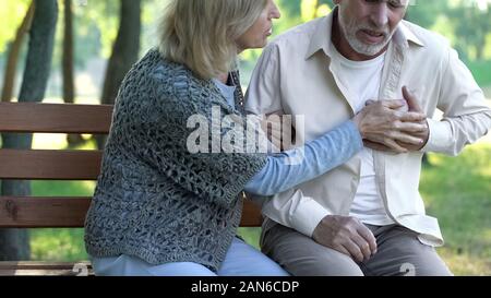 Reife männliche leiden Herz Schmerzen beim Spaziergang mit Frau, Herzinfarkt, Gesundheitswesen Stockfoto