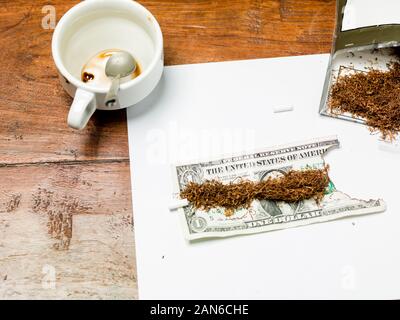 Schnupftabak mit einem Dollar Bill, verbranntes Geld Stockfoto