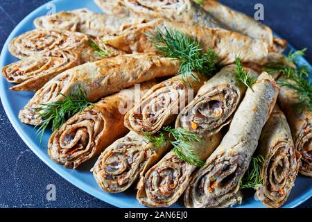 Buchweizen Crêpe-Brötchen mit Fleisch, Gemüse und Pilze auf einem Schild an einer konkreten Tabelle, Ansicht von oben, close-up Stockfoto