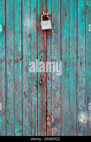 Detail der Grüne alte Holztür mit einem Vorhängeschloss Stockfoto