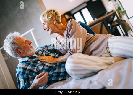 Glücklich lächelnde senior Paar zusammen zu Hause umarmen Stockfoto