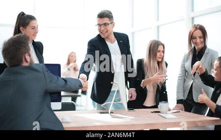 Geschäft Leute schütteln sich die Hände über einen Schreibtisch. Stockfoto