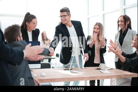 Geschäft Leute schütteln sich die Hände über einen Schreibtisch. Stockfoto