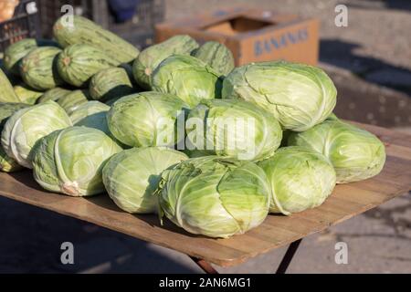 Blick auf eine Reihe von Salatköpfen/Cabbages. Wird auf einem Markt zum Verkauf angeboten. Frisches Gemüse, wie eine Pyramide gestapelt. Landwirtschaft, Bauernmarkt. Stockfoto