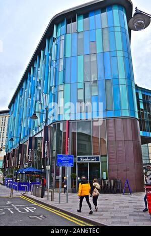 Ein Straßenblick auf das moderne Cardiff Central Bibliotheksgebäude, das auch von einer Mischung von Restaurants im Erdgeschoss, darunter "Carluccio's", belegt ist Stockfoto