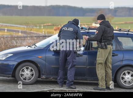 14. Januar 2020, Brandenburg, Frankfurt (Oder): Sven Umland (l), Senior Polizeichef an der Föderalen Polizei und Damian Kuzynin, aus der polnischen Grenzbeamten, überprüfen Sie die Reisenden mit dem Auto auf der Autobahn 12, während die deutschen und polnischen Grenzbeamten Patrouille Oder und Neisse zusammen, und seit Herbst haben auch die Patrouillen in neue Fahrzeuge. Dennoch, der Kampf gegen die grenzüberschreitende Kriminalität bleibt schwierig, nicht zuletzt aufgrund der Verkehrsdichte. Foto: Patrick Pleul/dpa-Zentralbild/ZB Stockfoto