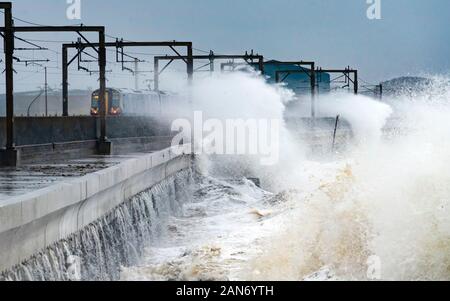 Große Wellen brechen über Straße und Eisenbahnlinie in Saltcoats während Sturm Brendan am 13. Januar 2020. Ayrshire, Schottland, Großbritannien Stockfoto