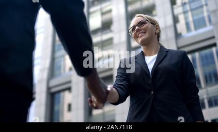 Junge Frau zitternden Hand mit Chef, herzlichen Glückwunsch zur Einstellung oder Beförderung Stockfoto