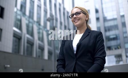 Freundliche Frau in Anzug erfüllt die ausländischen Geschäftspartnern, Dolmetscher oder Hostess Stockfoto